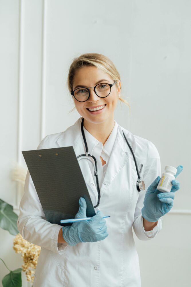 Felame doctor holding a note board in her right hand and a medications with her left hand